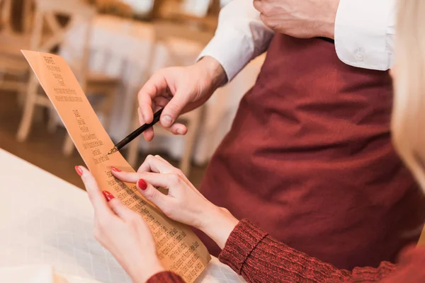 Cliente preguntando camarero sobre el menú - foto de stock