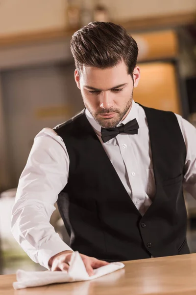 Bartender cleaning bar counter — Stock Photo