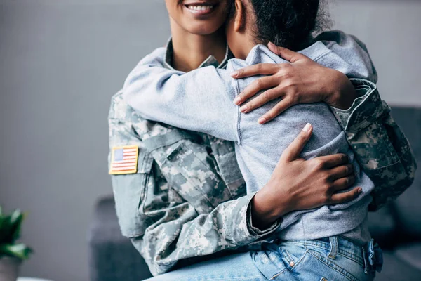 Figlia abbracciare madre in uniforme militare — Foto stock