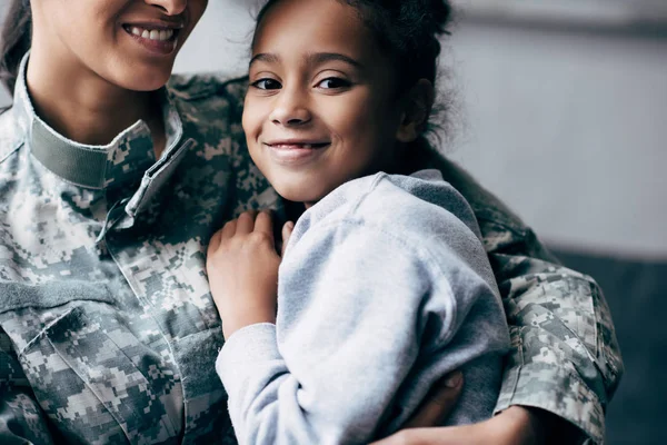 Hija abrazando soldado - foto de stock