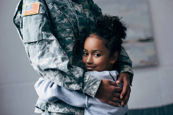 Hija abrazando soldado - foto de stock