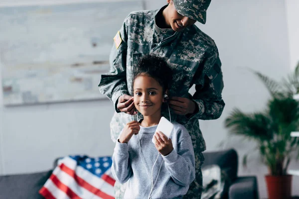 Hija y madre en uniforme militar - foto de stock