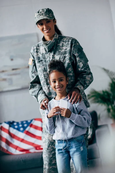 Hija y madre en uniforme militar - foto de stock