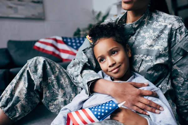 Hija y soldado con bandera americana - foto de stock