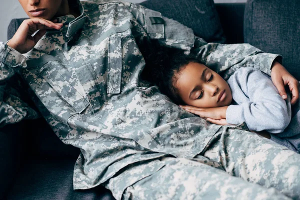 Mother in military uniform with sleeping daughter — Stock Photo