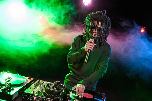 DJ in headphones with mixer in nightclub — Stock Photo