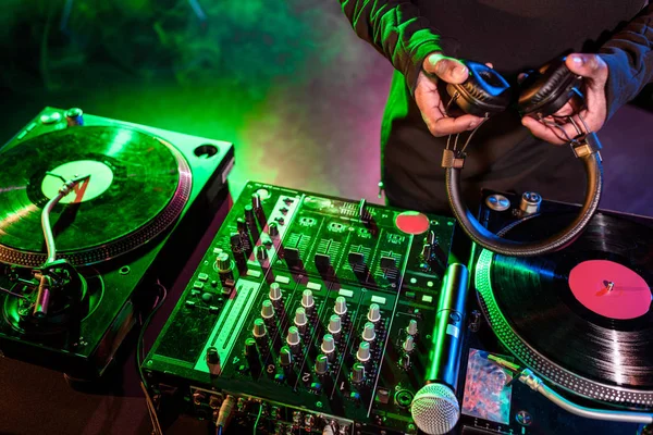 DJ con auriculares sobre mezclador de sonido — Stock Photo