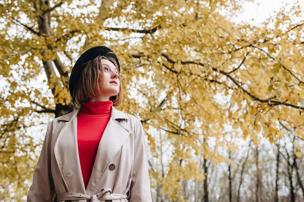 Mujer en gabardina en el parque de otoño - foto de stock