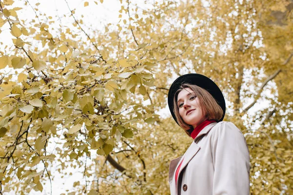 Donna in trench e cappello in parco — Foto stock