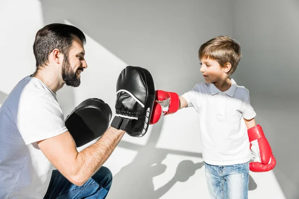 Отец и сын вместе занимаются боксом — стоковое фото