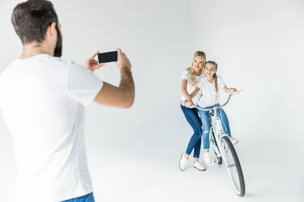 Мужчина фотографирует семью со смартфоном — стоковое фото