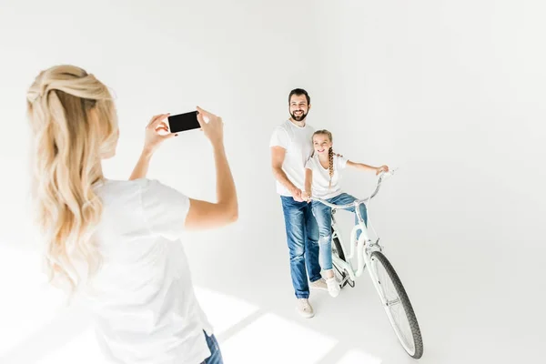 Mujer fotografiando familia con smartphone - foto de stock