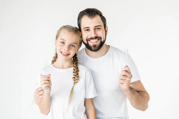 Отец и дочь с зубными щетками — стоковое фото