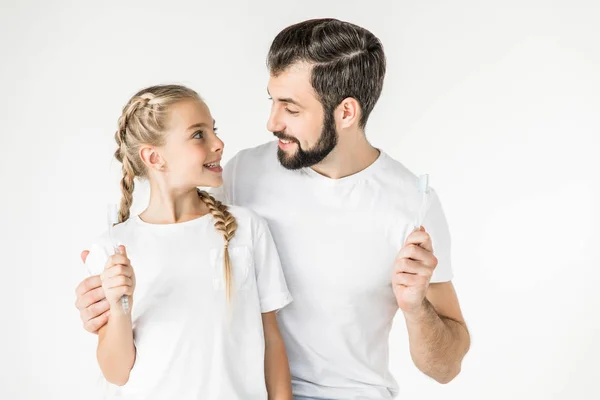 Padre e hija con cepillos de dientes - foto de stock