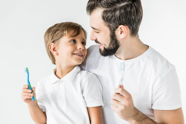 Padre e hijo con cepillos de dientes - foto de stock