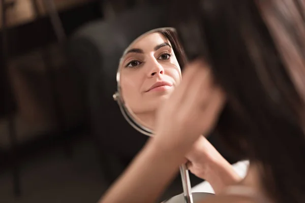 Femme regardant dans le miroir — Photo de stock