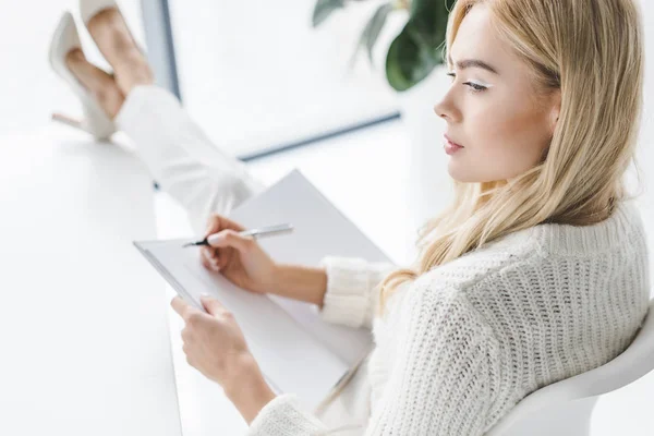 Mujer de negocios pensativa con papeleo - foto de stock