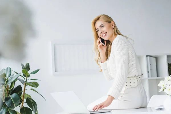 Mujer de negocios que trabaja con portátil y teléfono inteligente - foto de stock