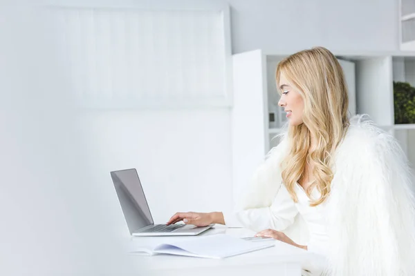 Blonde businesswoman using laptop — Stock Photo