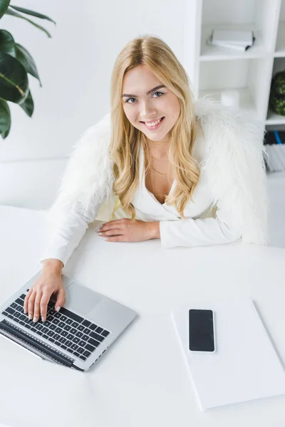 Femme d'affaires blonde souriante avec ordinateur portable — Photo de stock
