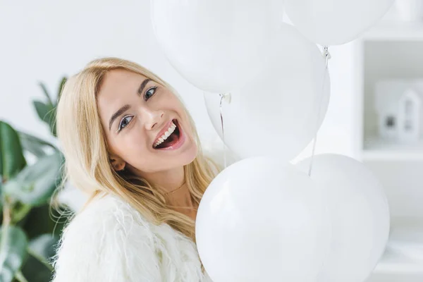 Mujer alegre con globos blancos - foto de stock