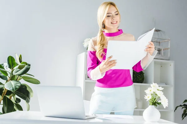 Geschäftsfrau mit Dokumenten und Laptop — Stockfoto