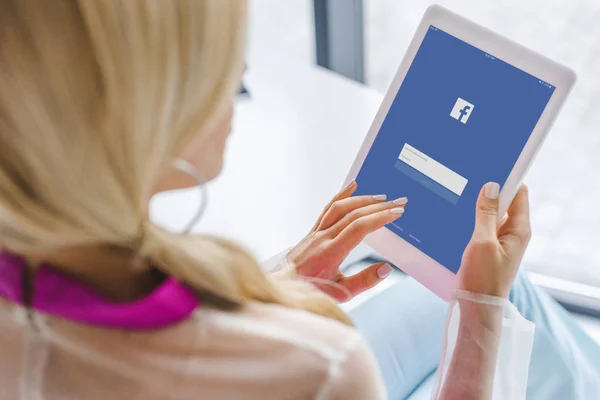 Frau nutzt Tablet mit Facebook — Stockfoto