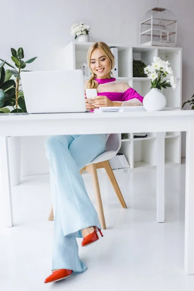 Mujer de negocios elegante sentado en el lugar de trabajo - foto de stock