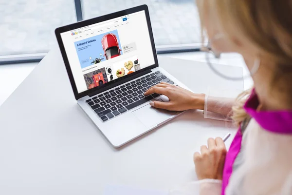 Mujer usando el ordenador portátil con eBay - foto de stock