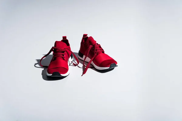 Vista de cerca de zapatillas rojas aisladas en gris - foto de stock