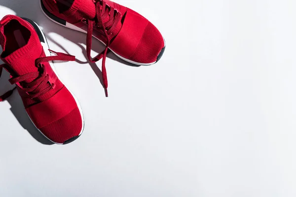 Vista de cerca de las zapatillas deportivas rojas aisladas en gris - foto de stock