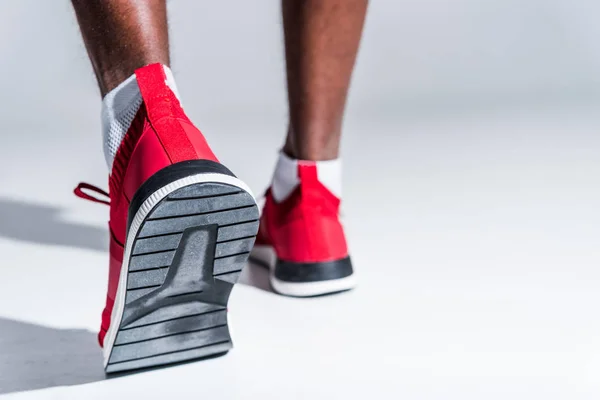 Enfoque selectivo del deportista afroamericano en zapatillas de deporte en gris — Stock Photo