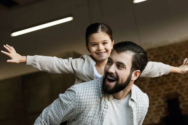 Glücklicher Vater gibt kleine Tochter zu Hause Huckepack zurück — Stockfoto