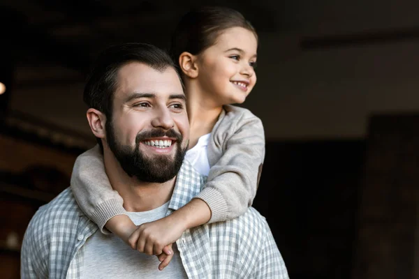 Pai e filha alegre abraçando e olhando para o lado. em casa — Fotografia de Stock