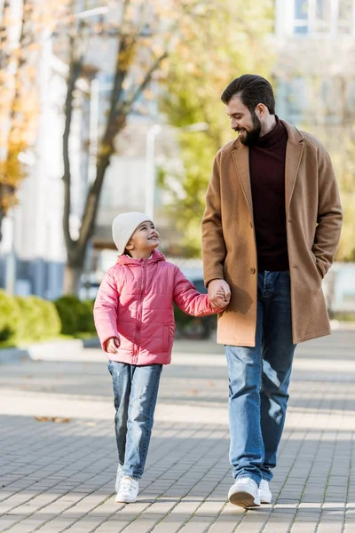 Cheerful father with little daughter walking outside in autumn outfit and looking at each other. outside — Stock Photo