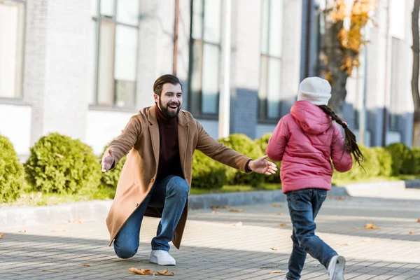 Little daughter running to hug her happy father. outside — Stock Photo