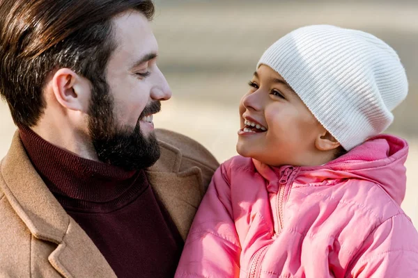 Padre feliz con la hija abrazándose y mirándose. afuera - foto de stock