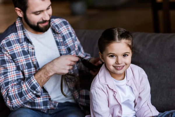 Vater bastelt Zöpfe für Tochter zu Hause — Stockfoto