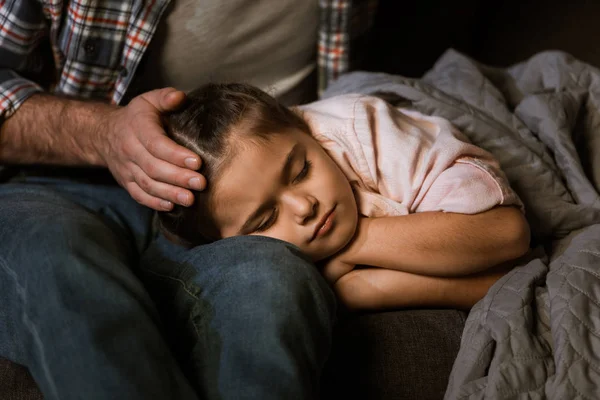Cropped image of little daughter fall asleep on fathers knees at home — Stock Photo