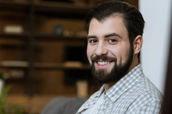 Young smiling attractive man with beard looking at camera — Stock Photo