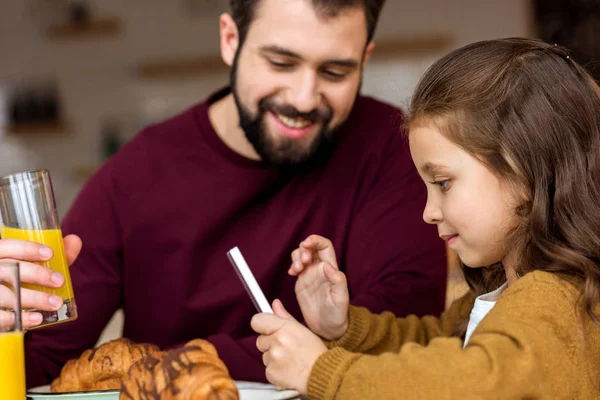 Tochter und Vater schauen im Café auf Tablet — Stockfoto