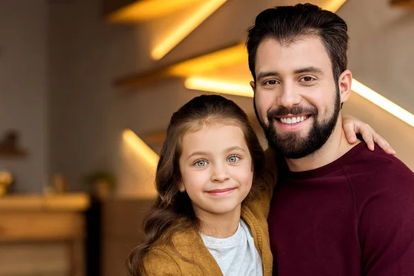 Feliz pai e filha abraçando e olhando para a câmera — Fotografia de Stock