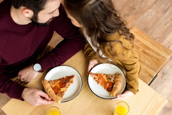 Над головой вид отца и дочери разговаривающих и сидящих в кафе с пиццей — стоковое фото