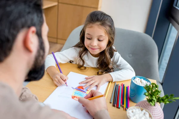 Cropped image of father and daughter drawing together with colored pencils — Stock Photo