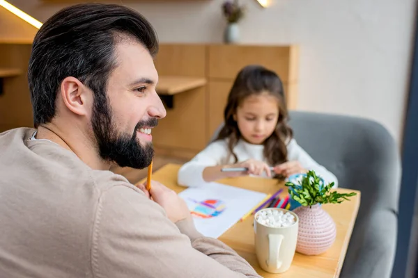 Усміхнений батько тримає олівець і дивиться геть — Stock Photo