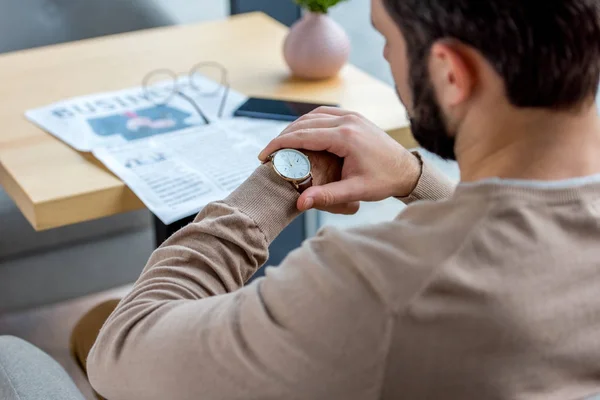 Cropped image of businessman waiting for meeting in cafe and looking at watch — Stock Photo