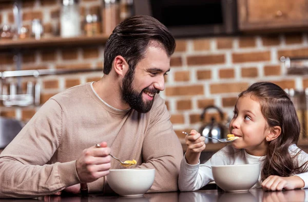 Lächelnd frühstücken Vater und Tochter und schauen einander an — Stockfoto