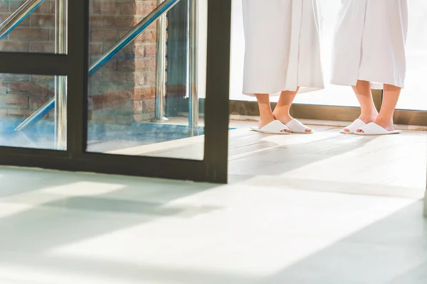 Cropped shot of women in bathrobes and slippers at spa center — Stock Photo