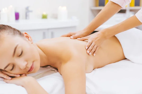 Relajada joven mujer teniendo masaje en el spa - foto de stock