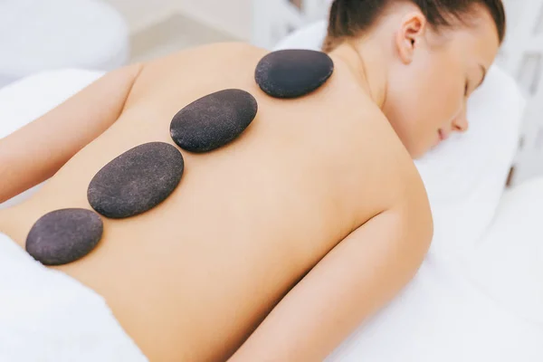 Gros plan de la femme ayant une thérapie de pierre au salon de spa — Photo de stock